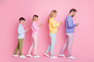 Fototapeta premium Full body profile side photo of dad mom small kids go typing sms on smartphone isolated over pastel color background