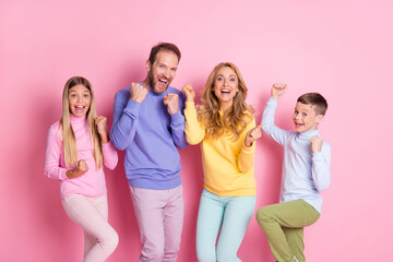 Photo of delighted family father mother little kids raise fists scream win isolated over pastel color background