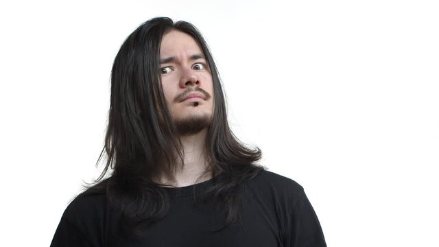 Close-up of east-asian guy with long hairstyle, piercing on face, looking surprised and shocked, reacting to something strange, standing in black t-shirt