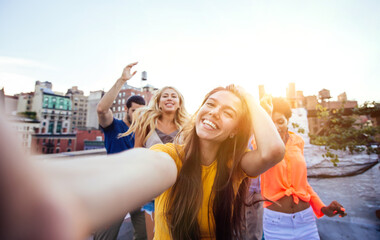 Group of friends spending time together on a rooftop in New york city, lifestyle concept with happy...