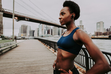 Athlete woman training in the morning at sunrise in New york city, Brooklyn in the background