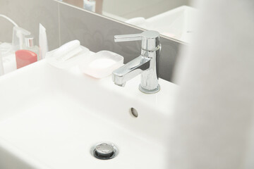 Faucet in the bathroom. Concept of washing hands, using water in the bathroom. Water pouring from the tap.