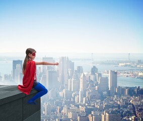 Young girl in superhero costume overlooking the city