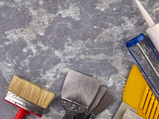 On a gray cement background are tools for finishing work,for putty and painting.Spatula ,paint...
