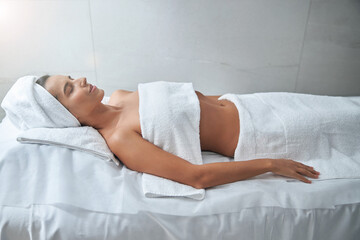 Obraz na płótnie Canvas Beautiful young woman lying on massage table in spa salon