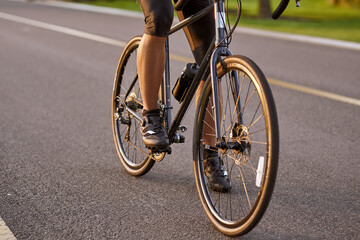 Riding. Cropped shot of a man cycling outdoors. Focus on male legs