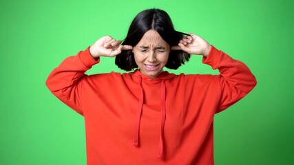 woman covering both ears with hands. Frustrated expression 