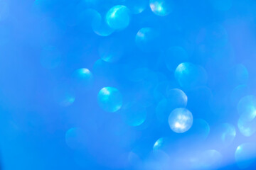 Blue abstract background bokeh blurred beautiful shiny lights Christmas. The background is shiny white. Divorces and blurry balls of light gray color.