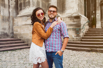Obraz na płótnie Canvas young couple in love traveling, vintage style, europe vacation, honey moon, sunglasses, old city center, happy positive mood, smiling, embracing