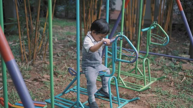 a boy was getting on swing horse