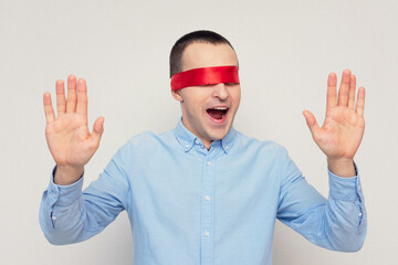 Excited man with red blindfold, portrait, white background