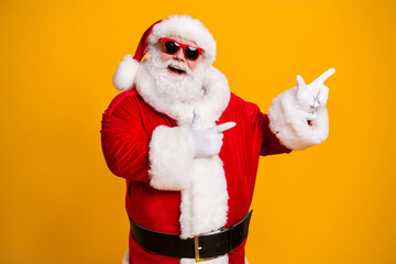 Portrait of his he nice attractive cheerful cheery fat Santa pointing presenting copy space newyear party idea shopping isolated over bright vivid shine vibrant yellow color background