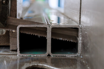 Cutting steel profiles on a band saw in production.