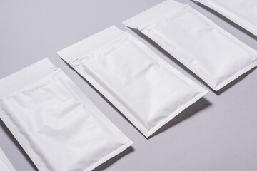 Lot of white paper bubble envelopes on grey background, textured background