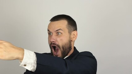 A young successful businessman funny portrays a karate, punches the air with his hands. Portrait of a young successful businessman he funny portrays a fight imitating karate. - Powered by Adobe