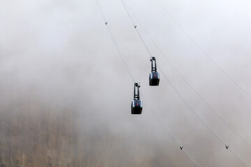 Chairlift climbs through the mist on the top of the mountain