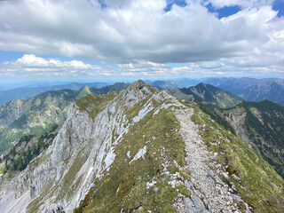 Die letzten Meter auf dem Grat zum Hochplatte Gipfel in den Ammergauer Alpen in Deutschland. Das Gipfelkeuz der Hochplatte ist mittig erkennbar.