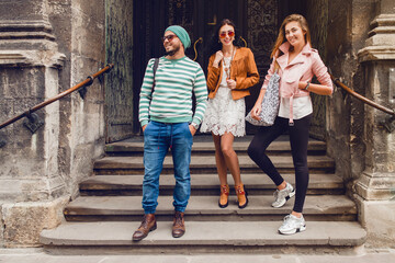 Naklejka premium young hipster company of friends traveling, vintage style, europe vacation, sunglasses, old city center, happy positive mood, smiling, embracing, pointing finger, looking forward