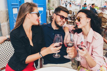 young hipster company of friends sitting at cafe, drinking wine on Europe vacation