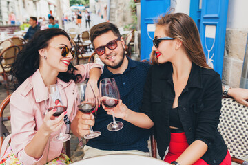 young hipster company of friends sitting in city street cafe, holding glasses, toasting, celebrating, drinking wine, sunglasses, summer vacation, party, having fun, smiling, happy, positive