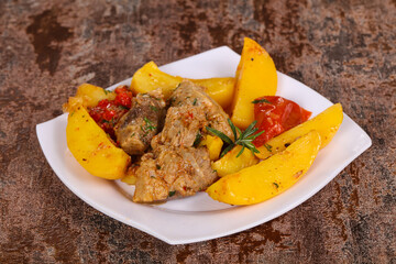 Baked pork meat with potao and tomato