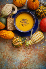 Compositon with autumn classic food. Tasty homemade pumpkin soup decorated with black seed