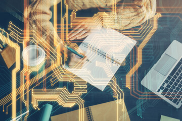Tech theme hologram over woman's hands taking notes background. Concept of hightech. Double exposure