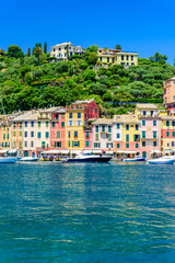 Portofino, Italy - Harbor town with colorful houses and yacht in little bay. Liguria, Genoa province, Italy. Italian fishing village with beautiful sea coast landscape in summer season.