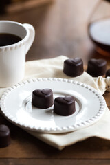 Heart-shaped chocolate pralines and coffee on a table