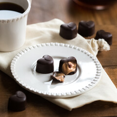 Heart-shaped chocolate pralines and coffee on a table