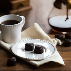 Heart-shaped chocolate pralines and coffee on a table