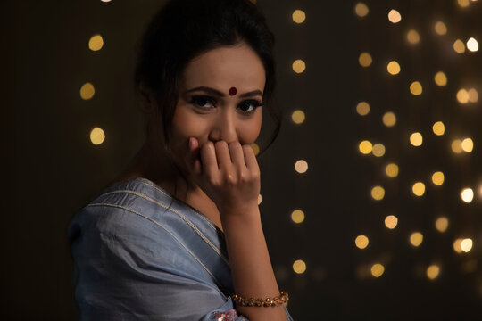 Woman smiling shyly with her hand on her lips	