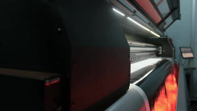 Drying the prints by heating. Printing machine that dries the print with its heated fans. Large format digital printing machine and moving print head.