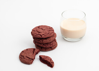 Cherry velvet cookies and glass of melted milk on white background.