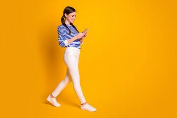 Fototapeta na wymiar Full size profile side photo of positive girl use cellphone have social media communication chilling wear white clothes shoes isolated over bright shine color background