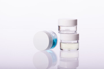 Transparent jars cosmetic liquids isolated on white background. Eyes face nail care, natural...