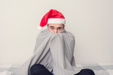 Afraid Santa sitting at home on self-isolation, portrait, white background