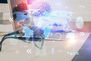 Double exposure of world map hologram with man working on computer on background. Concept of worldwideweb.