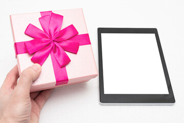 Man with pink gift and tablet. Men's hand, closeup, white background, copy space, top view