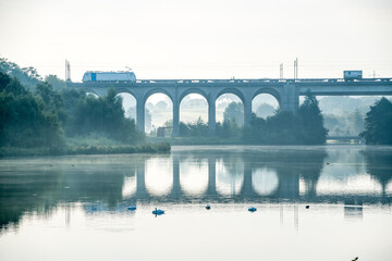 &Uuml;ber das Viadukt am Obersee in Bielefeld f&auml;hrt ein G&uuml;terzug und die Szene spiegelt sich im See