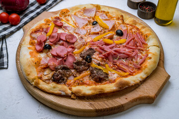 Pizza four seasons on white concrete table