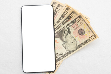 American dollars and smartphone screen, white background, copy space, top view