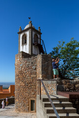 Obraz premium View at a tourist taking a photo with his phone, on interior medieval fortress village tower and medieval buildings