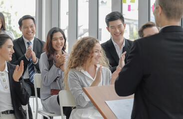 Candid business audience happy and smiley faces in seminar event. Young asian woman clapping hands together with others for congratulation to colleague at conference meeting room. Selective focus.