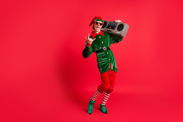 Full size photo of crazy elf hold boom box listen x-mas songs show horned symbol wear green costume...