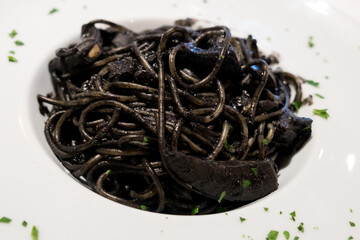 Delicious Italian black pasta with cuttlefish ink and fillet