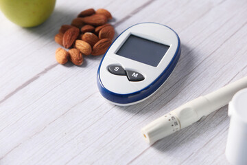  diabetic measurement tools, almond nuts and apple on table 