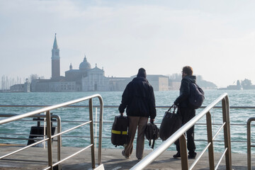 Tourists waiting for water taxi - vaporetto - on the harbor San Marco in Venice, Italy - obrazy, fototapety, plakaty