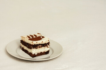 Piece of chocolate cake on a plate, drawing in the form of a Cup of coffee, side view, white background, copy space