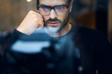 Concentrated thinking bearded guy in eyeglasses